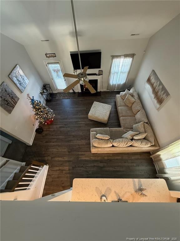 unfurnished living room with stairs, wood finished floors, and a ceiling fan