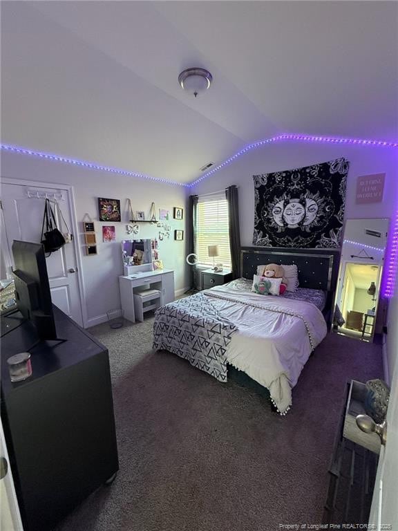 carpeted bedroom with lofted ceiling