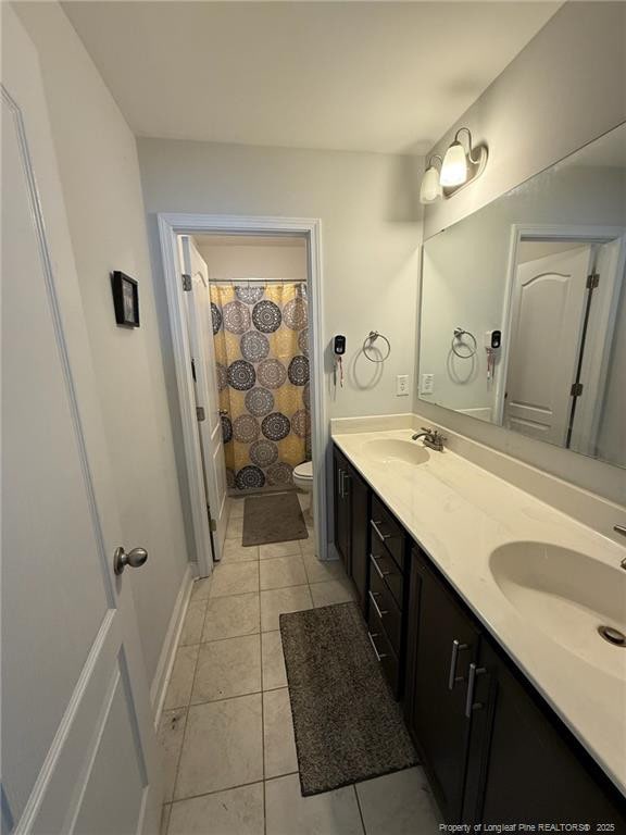 full bathroom featuring tile patterned flooring, a sink, toilet, and double vanity