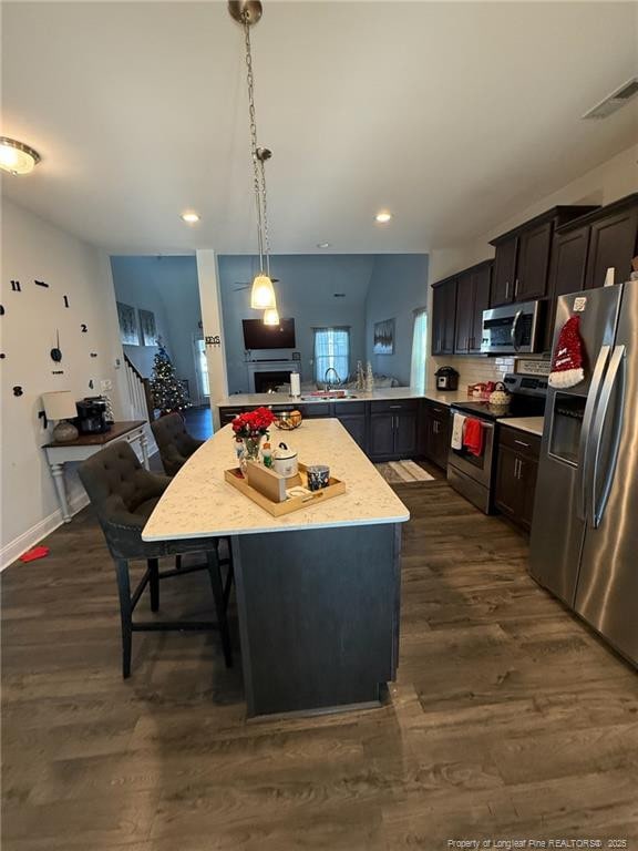 kitchen with visible vents, light countertops, appliances with stainless steel finishes, hanging light fixtures, and dark wood finished floors