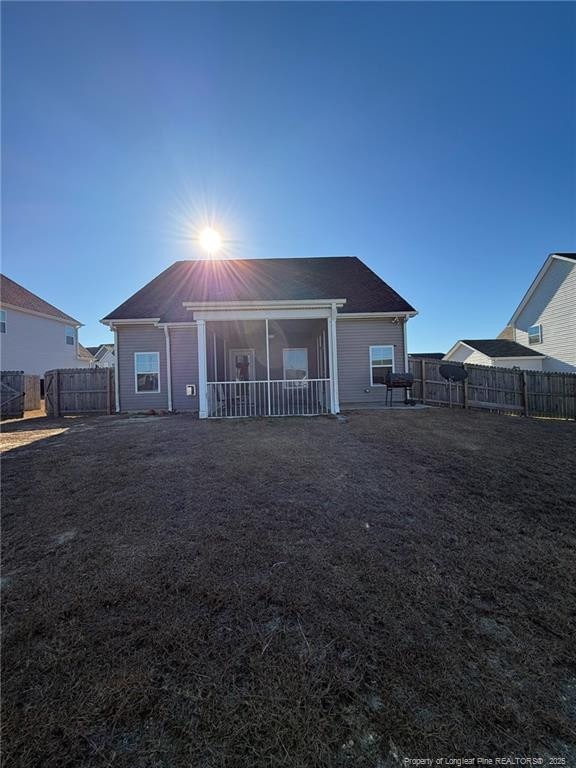 back of property featuring a fenced backyard and a yard