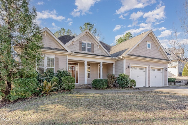 craftsman house featuring a garage, covered porch, and a front lawn