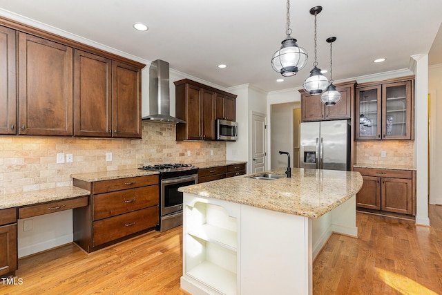 kitchen with sink, decorative light fixtures, stainless steel appliances, a kitchen island with sink, and wall chimney range hood