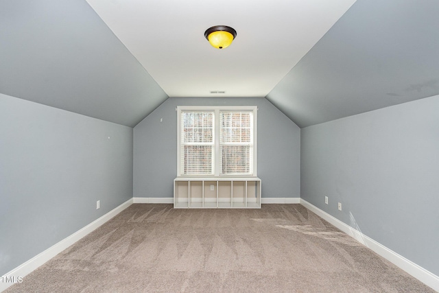 bonus room featuring vaulted ceiling and carpet