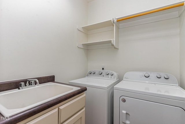 washroom featuring sink, washing machine and dryer, and cabinets