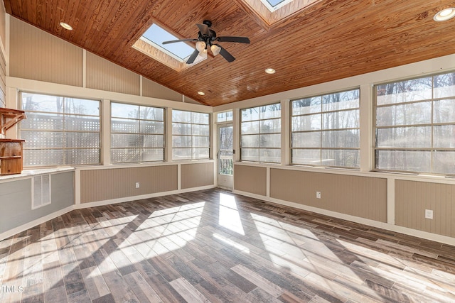 unfurnished sunroom featuring ceiling fan, vaulted ceiling with skylight, a wealth of natural light, and wooden ceiling