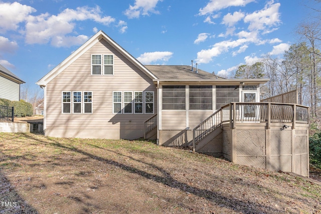 rear view of property with a yard and a sunroom