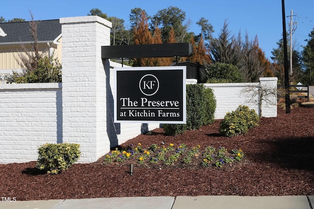 community / neighborhood sign featuring fence