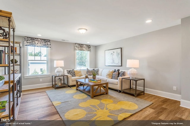 living room with recessed lighting, baseboards, and wood finished floors