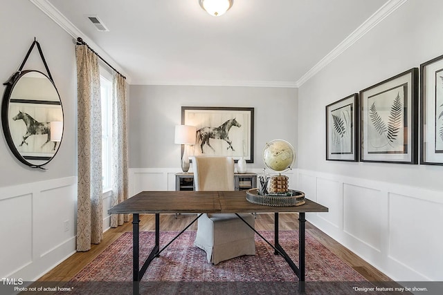 office area with wood finished floors, visible vents, ornamental molding, wainscoting, and a decorative wall