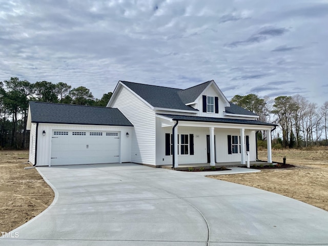 modern inspired farmhouse with a garage, a porch, driveway, and a shingled roof