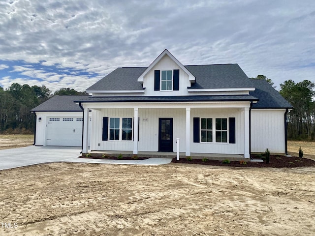 modern inspired farmhouse with covered porch, driveway, and a garage