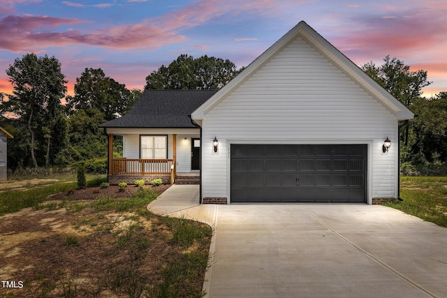 view of front facade featuring a porch, a garage, and a lawn