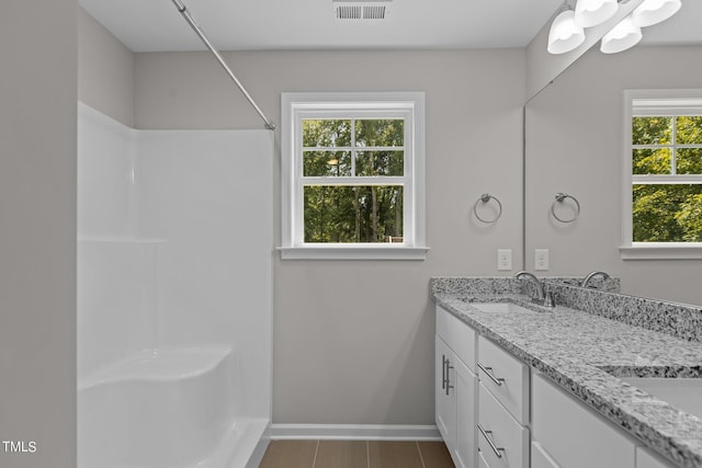 bathroom with vanity and a shower