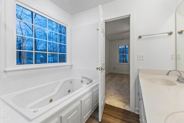 bathroom with vanity, a bath, and hardwood / wood-style flooring