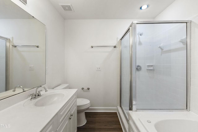 full bathroom with hardwood / wood-style floors, vanity, separate shower and tub, and toilet