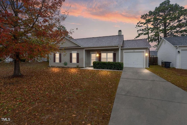 single story home featuring a lawn and a garage