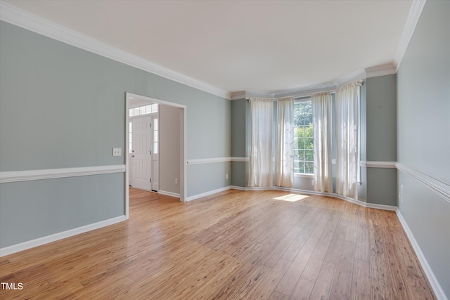 empty room with light wood-type flooring and ornamental molding