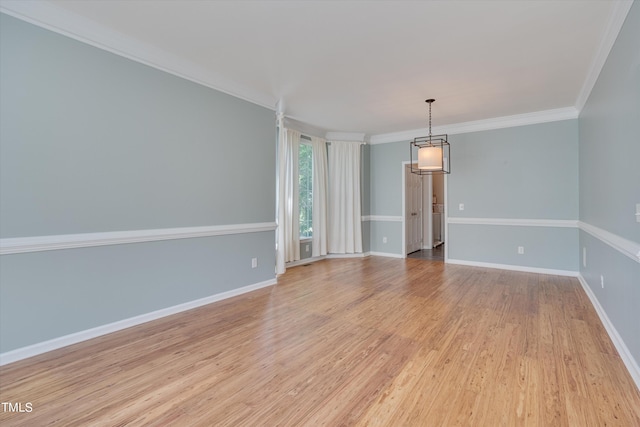 spare room featuring light wood-type flooring and crown molding