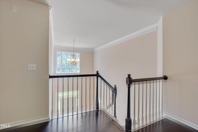 stairway featuring a notable chandelier, wood-type flooring, and crown molding