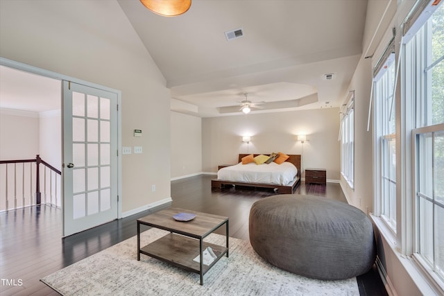 bedroom with a tray ceiling, ceiling fan, and dark wood-type flooring