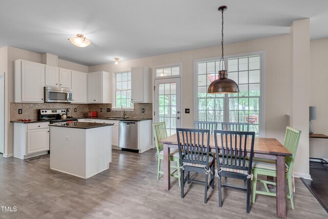 106 Dairy Ct, Chapel Hill, NC 27516 - kitchen featuring stainless steel appliances, a sink, dark countertops, decorative backsplash, and white cabinetry