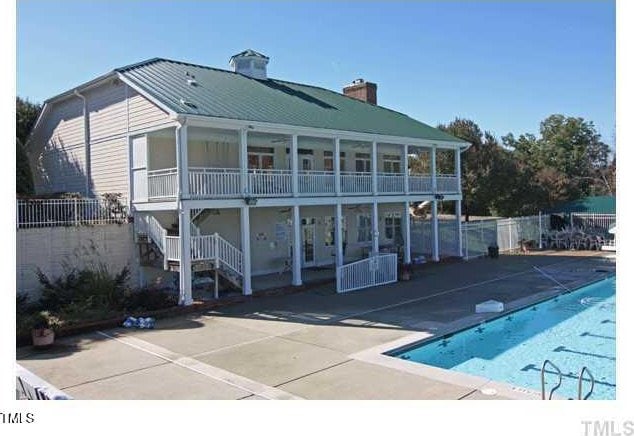 106 Dairy Ct, Chapel Hill, NC 27516 - back of property with a chimney, a community pool, a balcony, a patio, and metal roof