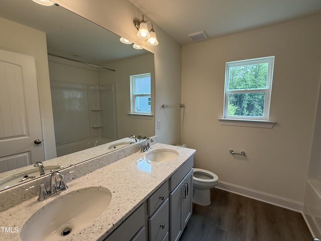 129 Stallion Way, Benson, NC 27504 - full bath with baseboards, wood finished floors, toilet, double vanity, and shower / washtub combination