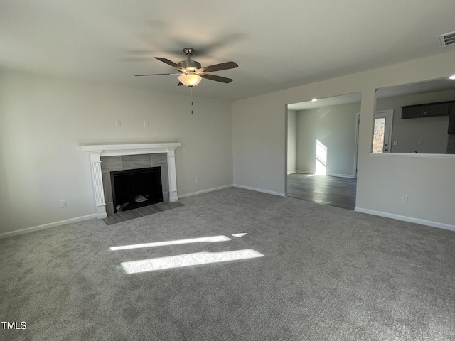 unfurnished living room with a fireplace, carpet floors, and ceiling fan