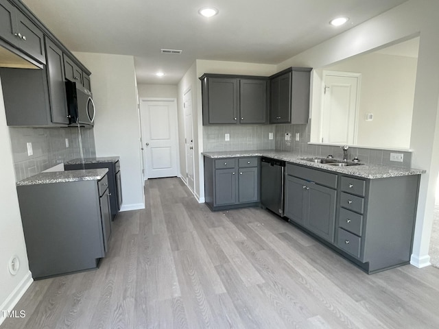 kitchen with light stone countertops, sink, light hardwood / wood-style flooring, gray cabinets, and appliances with stainless steel finishes