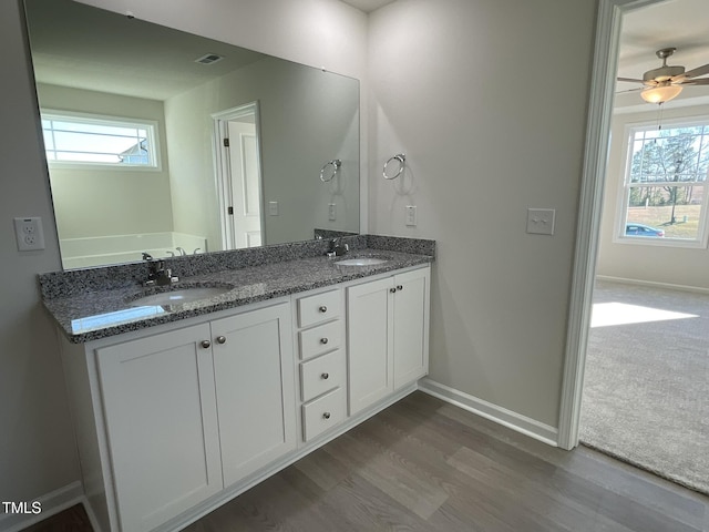 bathroom featuring hardwood / wood-style floors, vanity, a healthy amount of sunlight, and ceiling fan