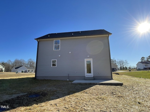 back of house with a patio area and a yard