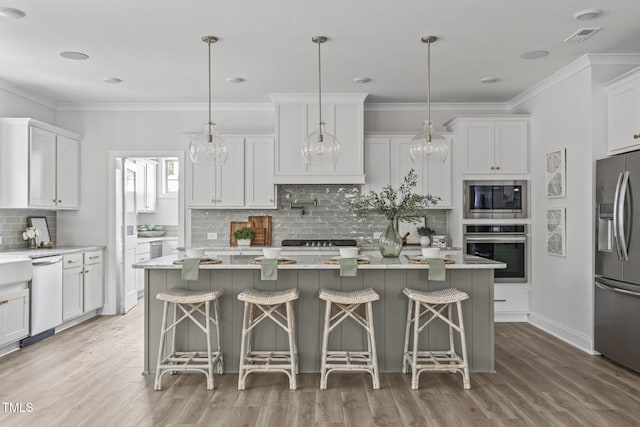 kitchen featuring visible vents, white cabinets, appliances with stainless steel finishes, light countertops, and crown molding