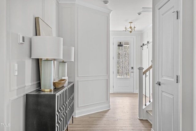 interior space with a barn door, light wood-style flooring, and a decorative wall