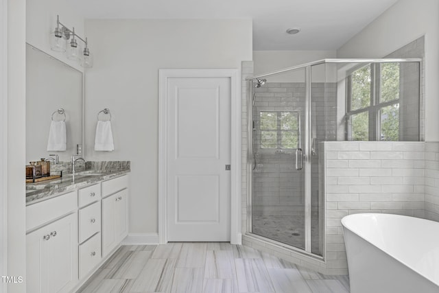 bathroom with a stall shower, a freestanding bath, and vanity