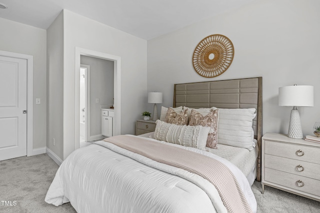 bedroom with ensuite bath, carpet, and baseboards