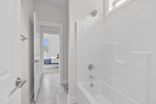 bathroom featuring bathtub / shower combination and baseboards