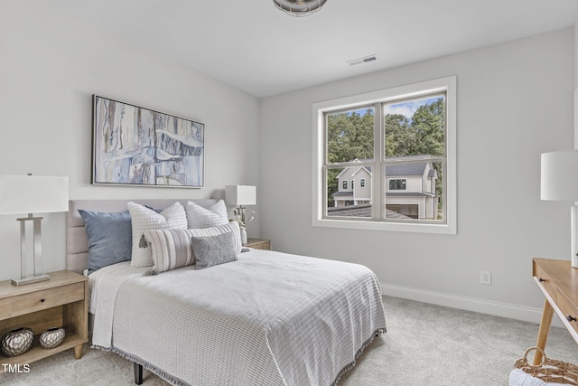 bedroom featuring light carpet, visible vents, and baseboards