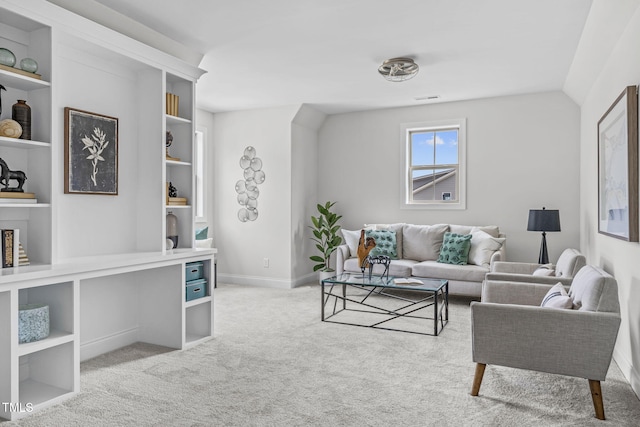 living area featuring lofted ceiling, built in shelves, light carpet, visible vents, and baseboards