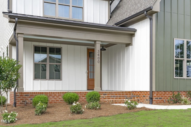 doorway to property featuring a shingled roof and board and batten siding