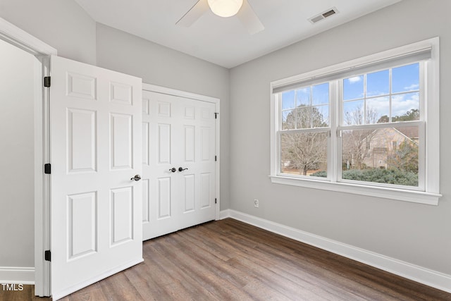 unfurnished bedroom featuring hardwood / wood-style floors, a closet, and ceiling fan