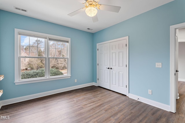 unfurnished bedroom with a closet, ceiling fan, and dark hardwood / wood-style flooring