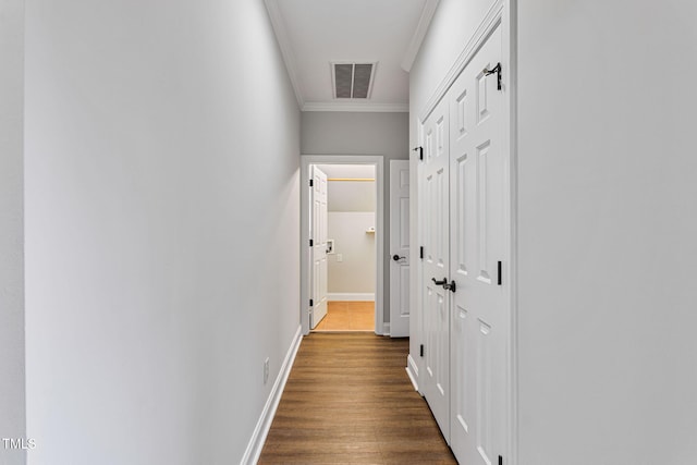 hallway featuring crown molding and dark hardwood / wood-style flooring