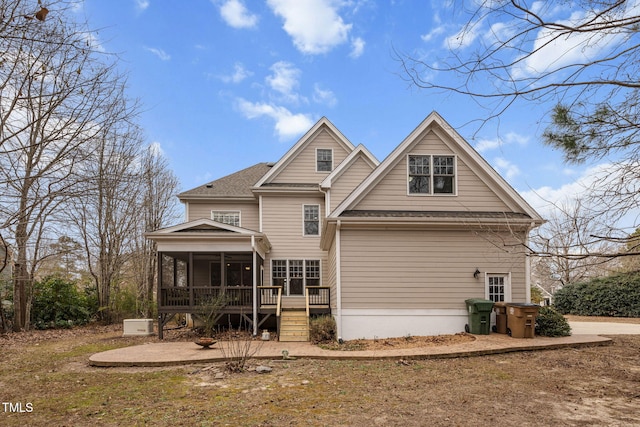 rear view of property featuring a sunroom and a patio area