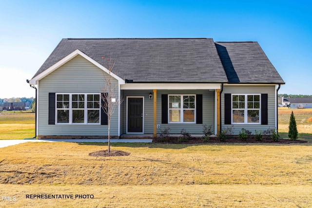 ranch-style home with a front yard and roof with shingles