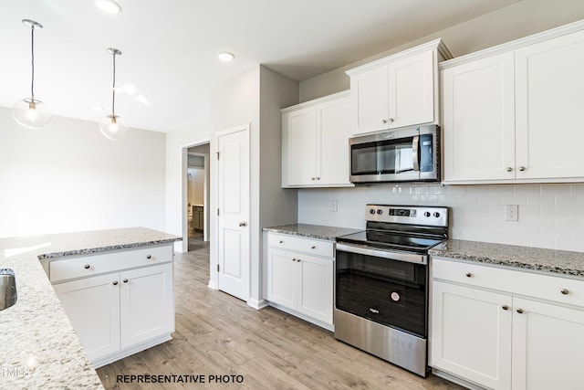 kitchen with stainless steel appliances, tasteful backsplash, light stone counters, white cabinets, and decorative light fixtures