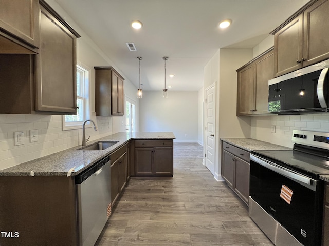 286 Longbow Dr, Middlesex, NC 27557 - kitchen featuring stainless steel appliances, a sink, a peninsula, backsplash, and wood finished floors