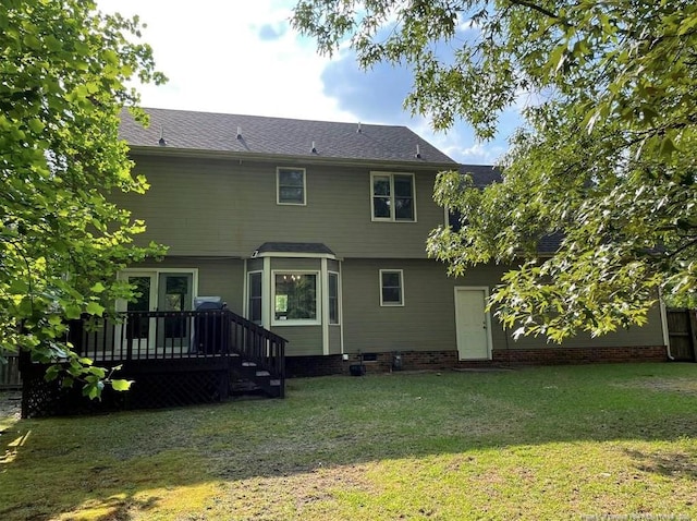 back of property featuring a lawn and a deck