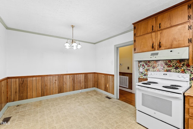 kitchen with wood walls, crown molding, decorative light fixtures, a chandelier, and electric range