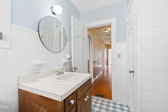 bathroom featuring vanity and tile walls